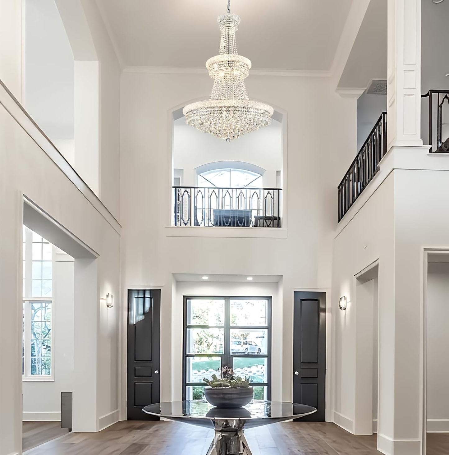 Luxurious interior of a home with a high ceiling, chandelier, and large windows.
