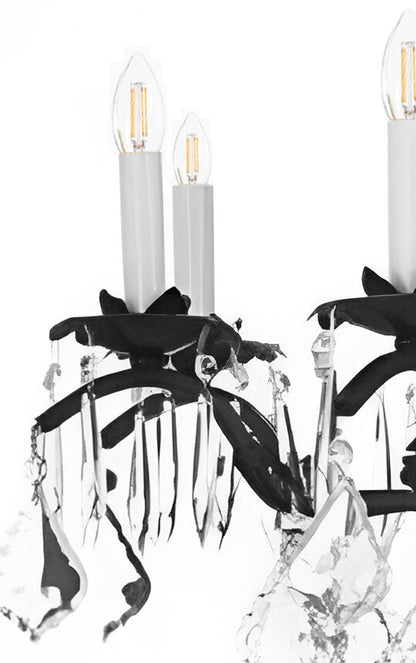 Crystal chandelier with black leaf accents on a white background