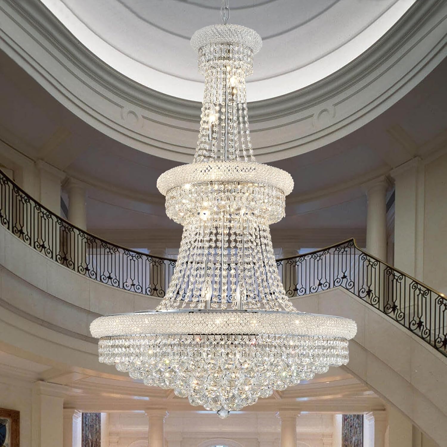 Large crystal chandelier hanging in a grand hallway with high ceilings and decorative railings.